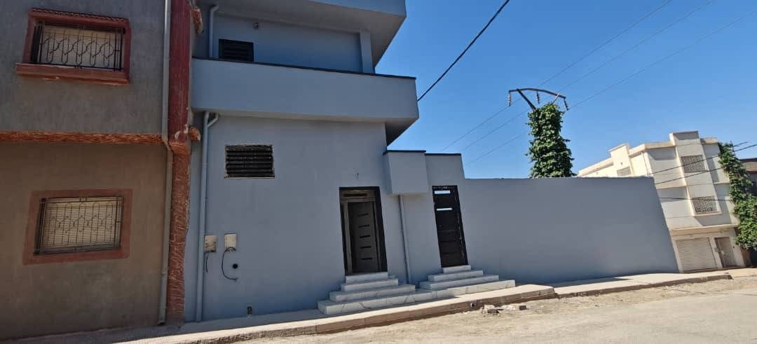 Façade achevée, balcons en verre et habillage en pierre
